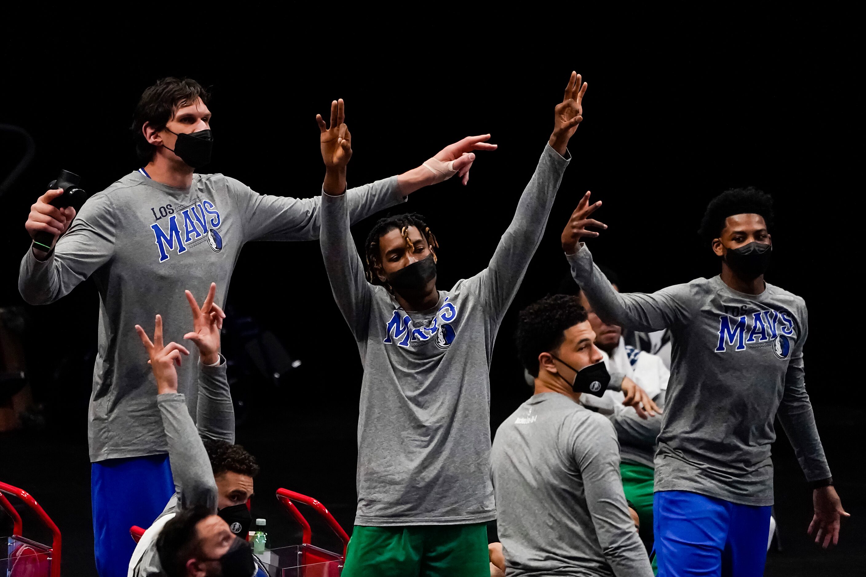 The Dallas Mavericks bench celebrates a 3-pointer by guard Luka Doncic during the second...