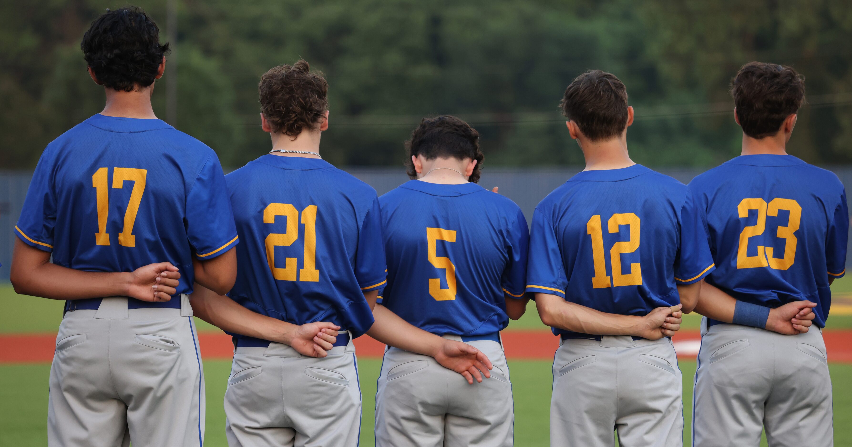 Frisco players pause for the playing of the national anthem prior to the first pitch of...