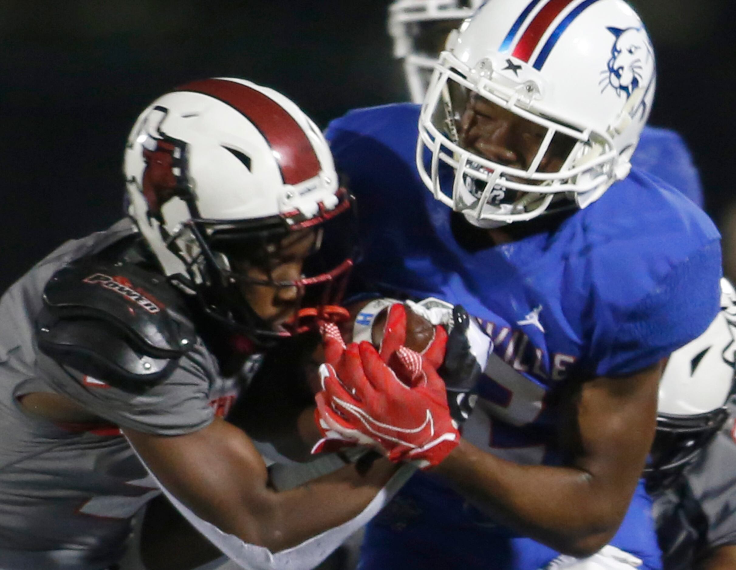 Duncanville receiver Lontrell Turner (22), right, winces as he works to maintain ball...