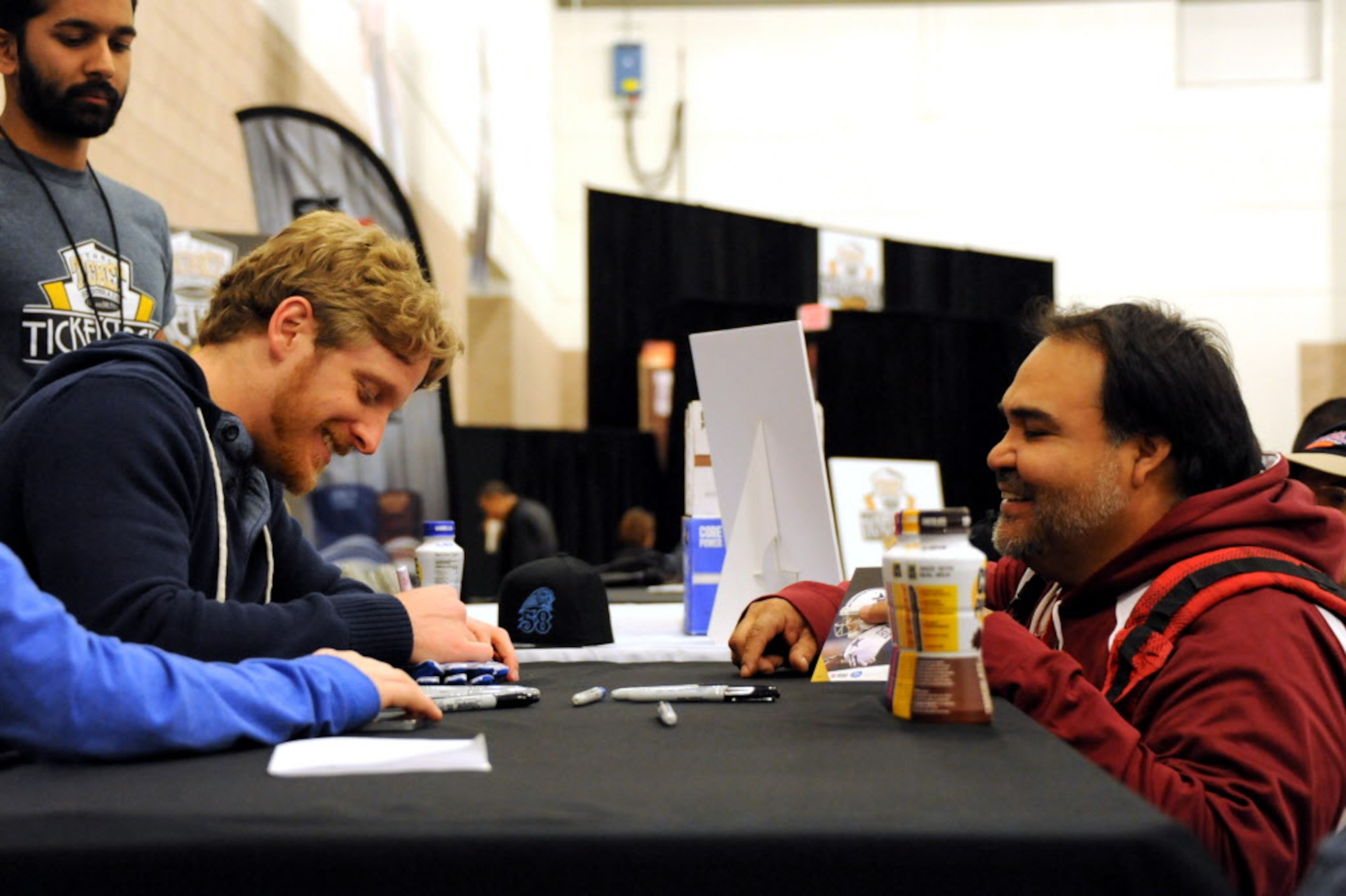 Dallas Cowboys wide receiver Cole Beasley signs a pair of gloves for a fan at The Ticket...