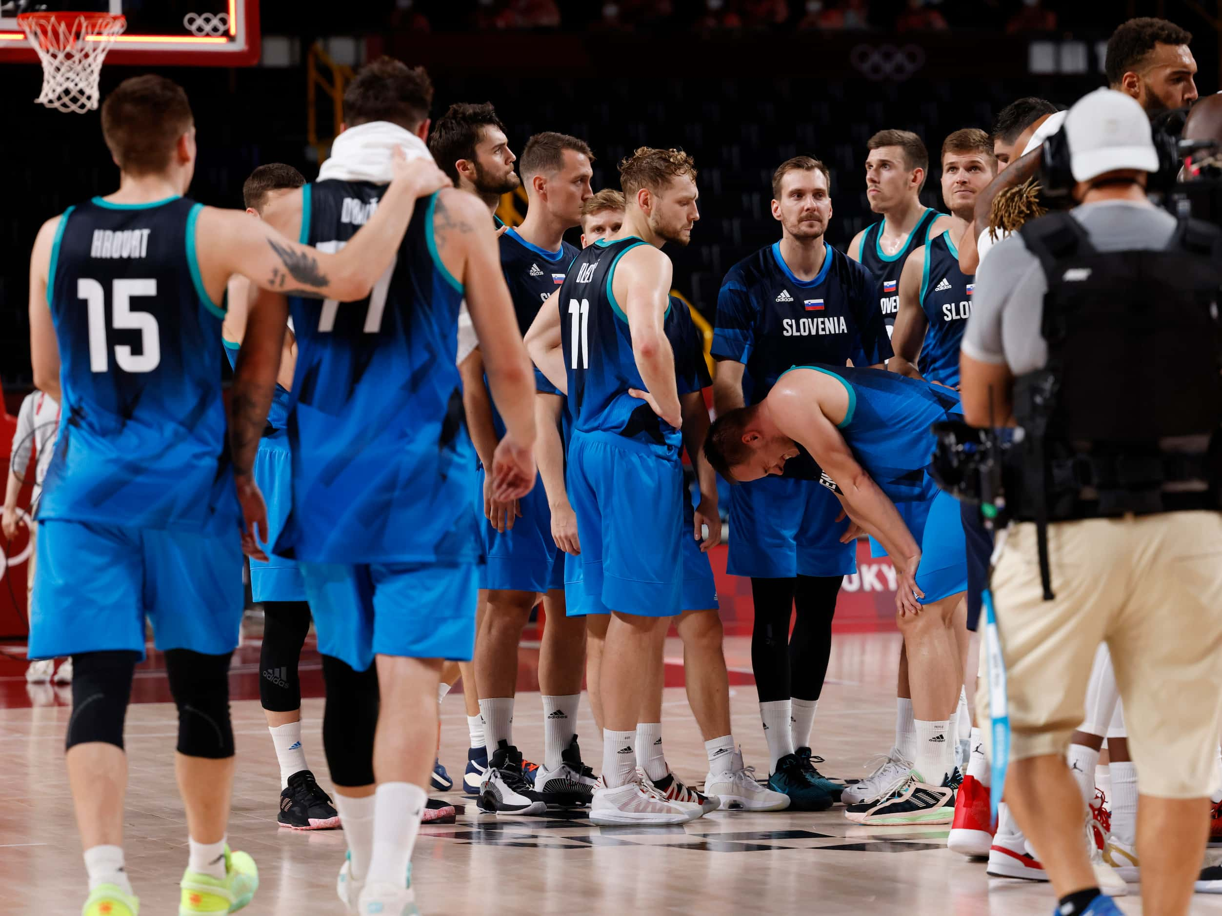 Slovenia’s Gregor Hrovat (15) and Luka Doncic (77) walk towards half court as teammates...