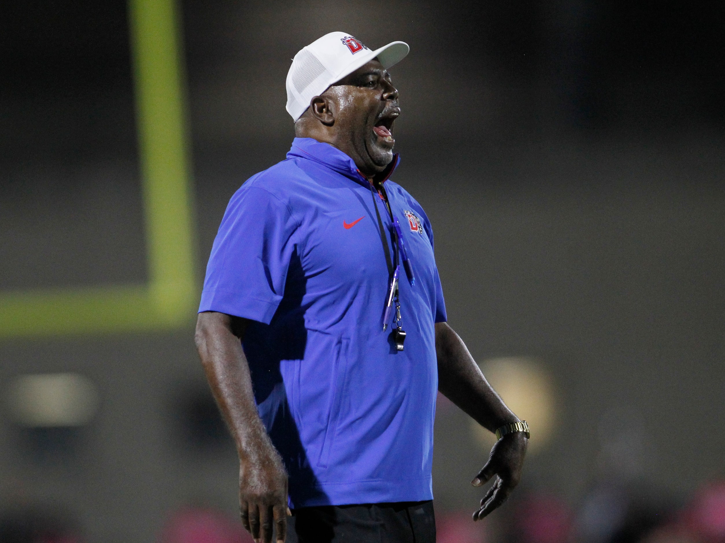 Duncanville head coach Reginald Samples works to get a message to his defensive players on...