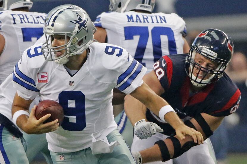 Dallas Cowboys quarterback Tony Romo (9) scrambles away from the pressure from Houston...