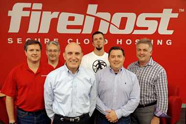  Former CEO Jim Lewandowski, blue shirt, front left, and Chris Drake, founder and now CEO,...