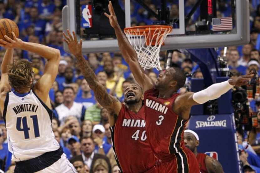 Miami Heat power forward Udonis Haslem (40) and shooting guard Dwyane Wade (3) try to defend...