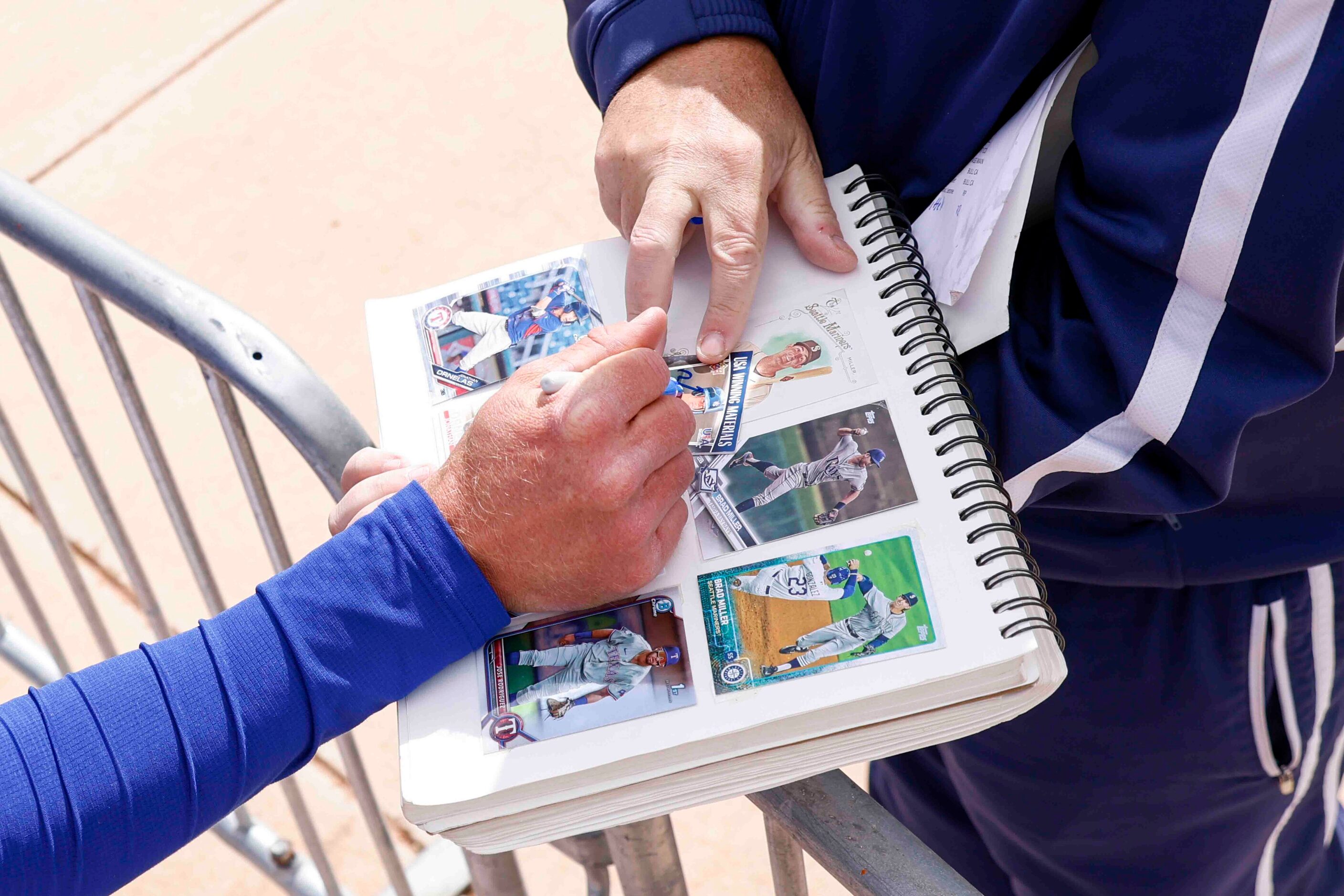 Texas Rangers outfielder Brad Miller signs an autograph for Matt Holly, of Los Angeles,...