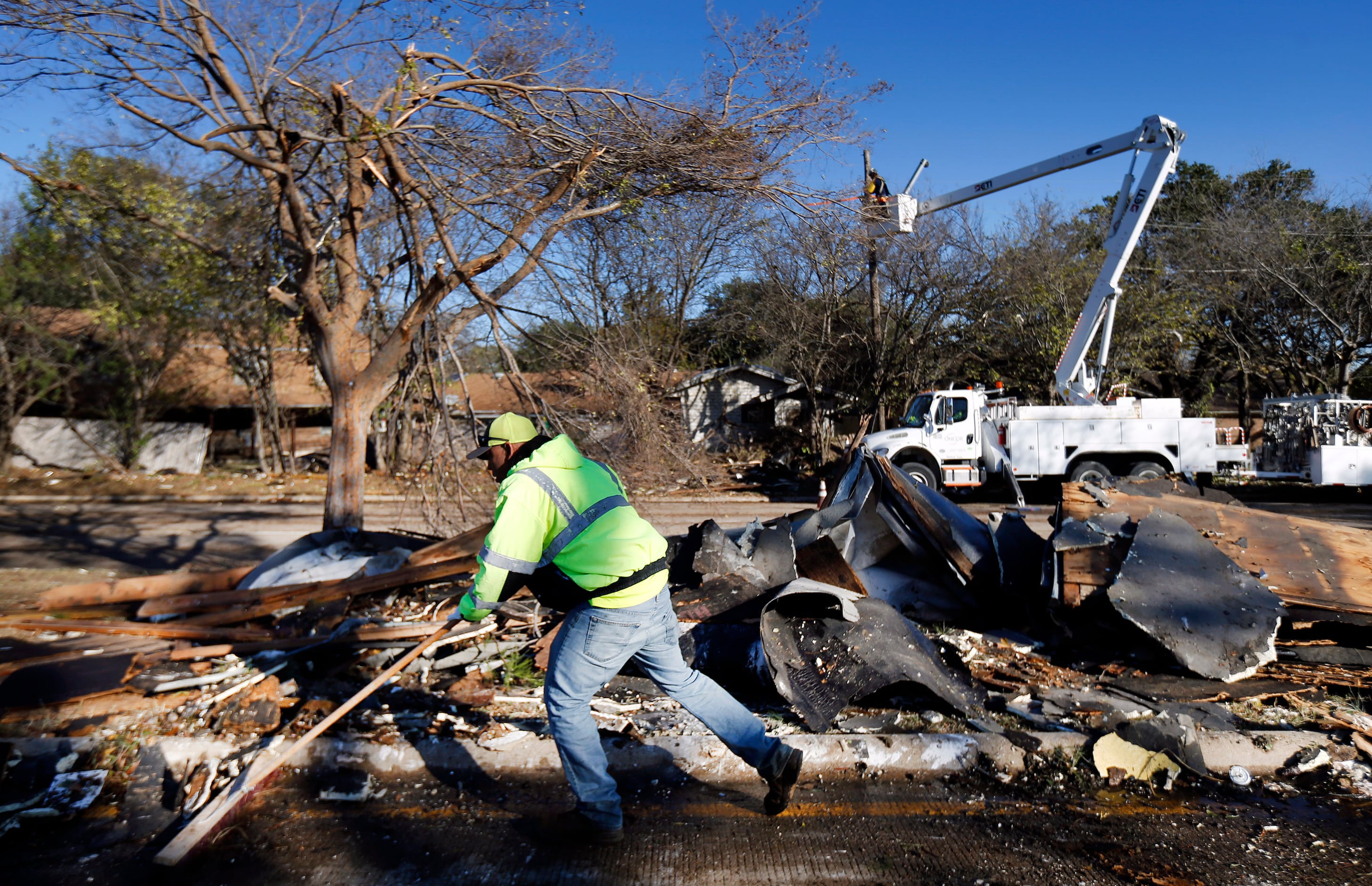 A City of Arlington street crewman cleans up debris from The Mirage Apartments complex along...