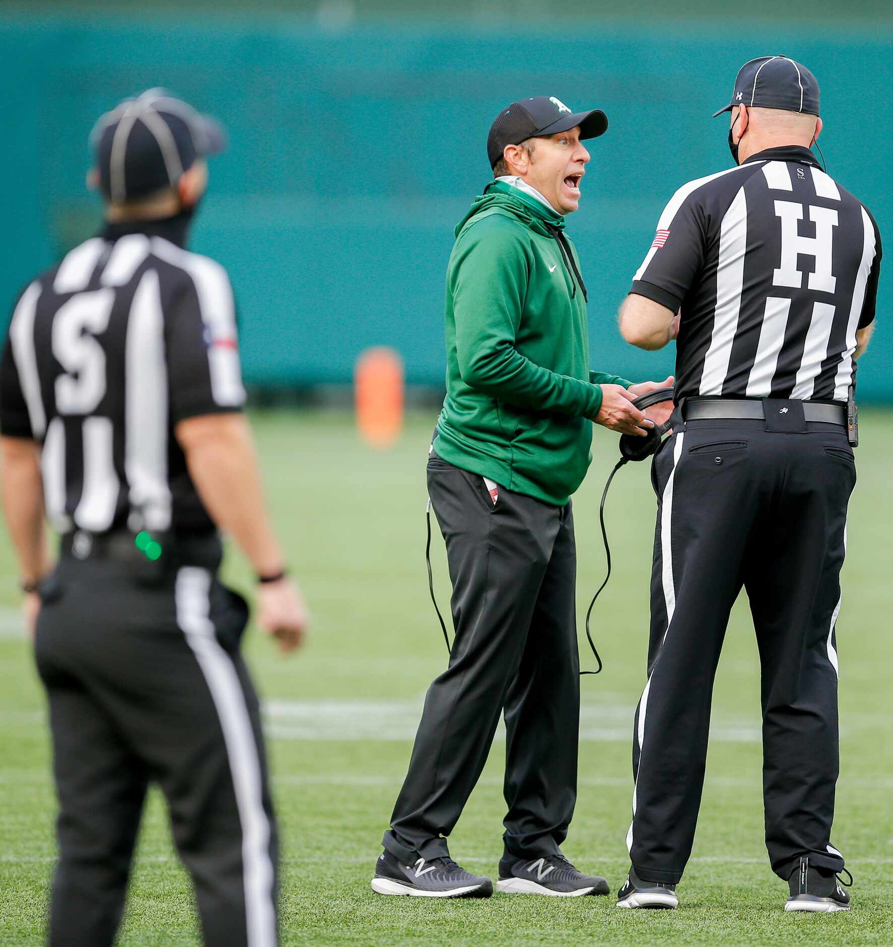 Arlington head coach Scott Peach argues an intentional grounding call during the first half...