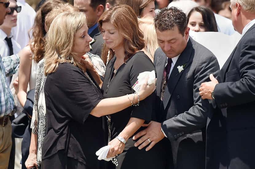 
Dondie Breaux (center), mother of Mayci Breaux, is consoled outside Church of the...