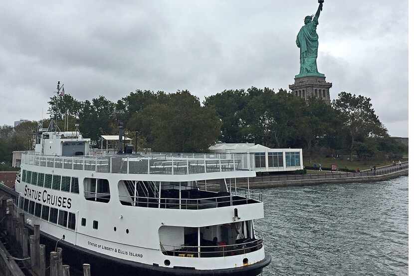 Foto de un ferry y la estatua de la libertad.