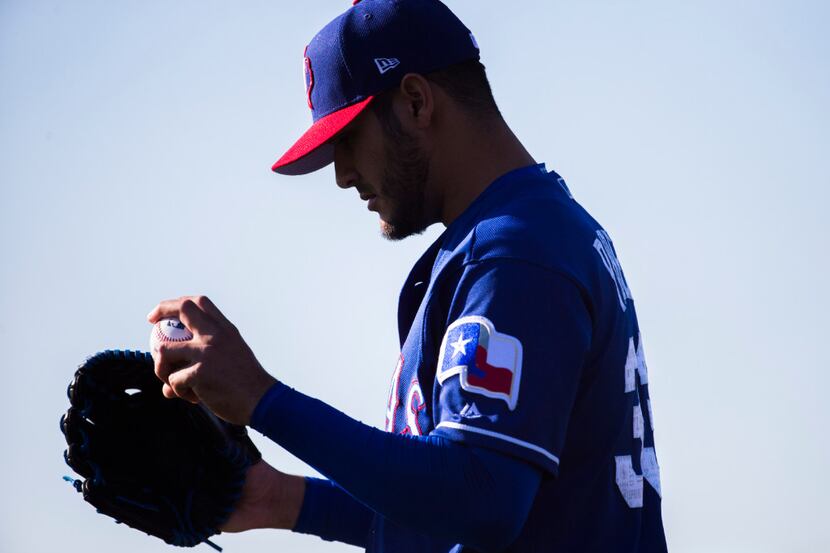 Texas Rangers starting pitcher Martin Perez (33) prepares to pitch during a spring training...