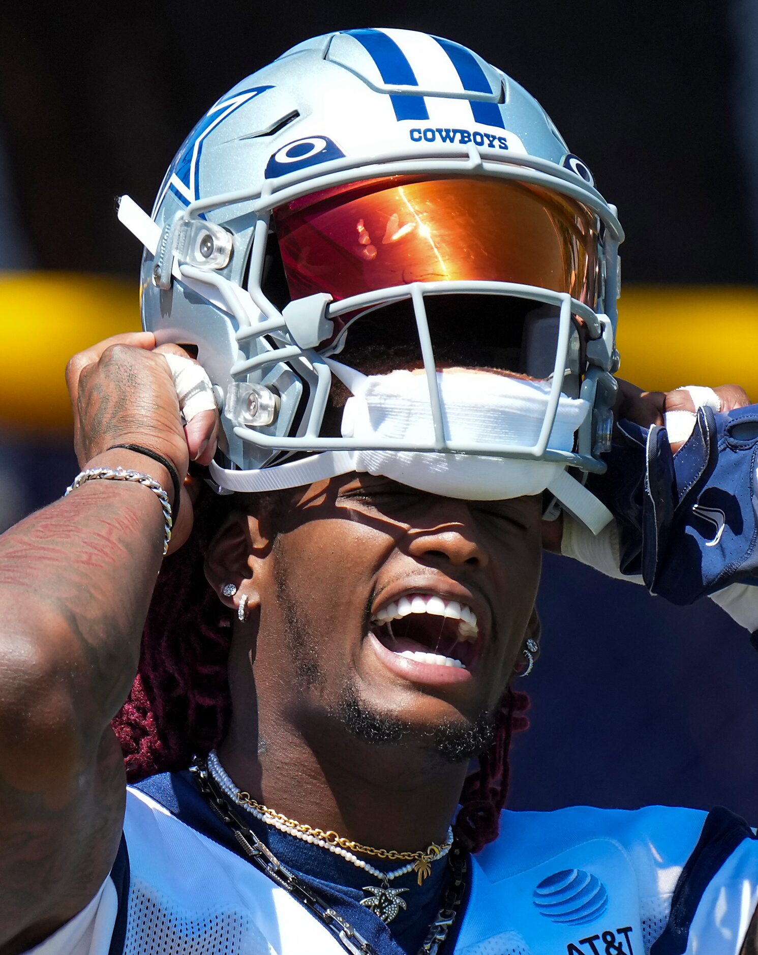 Dallas Cowboys wide receiver CeeDee Lamb puts on his helmet as he takes the field for a...