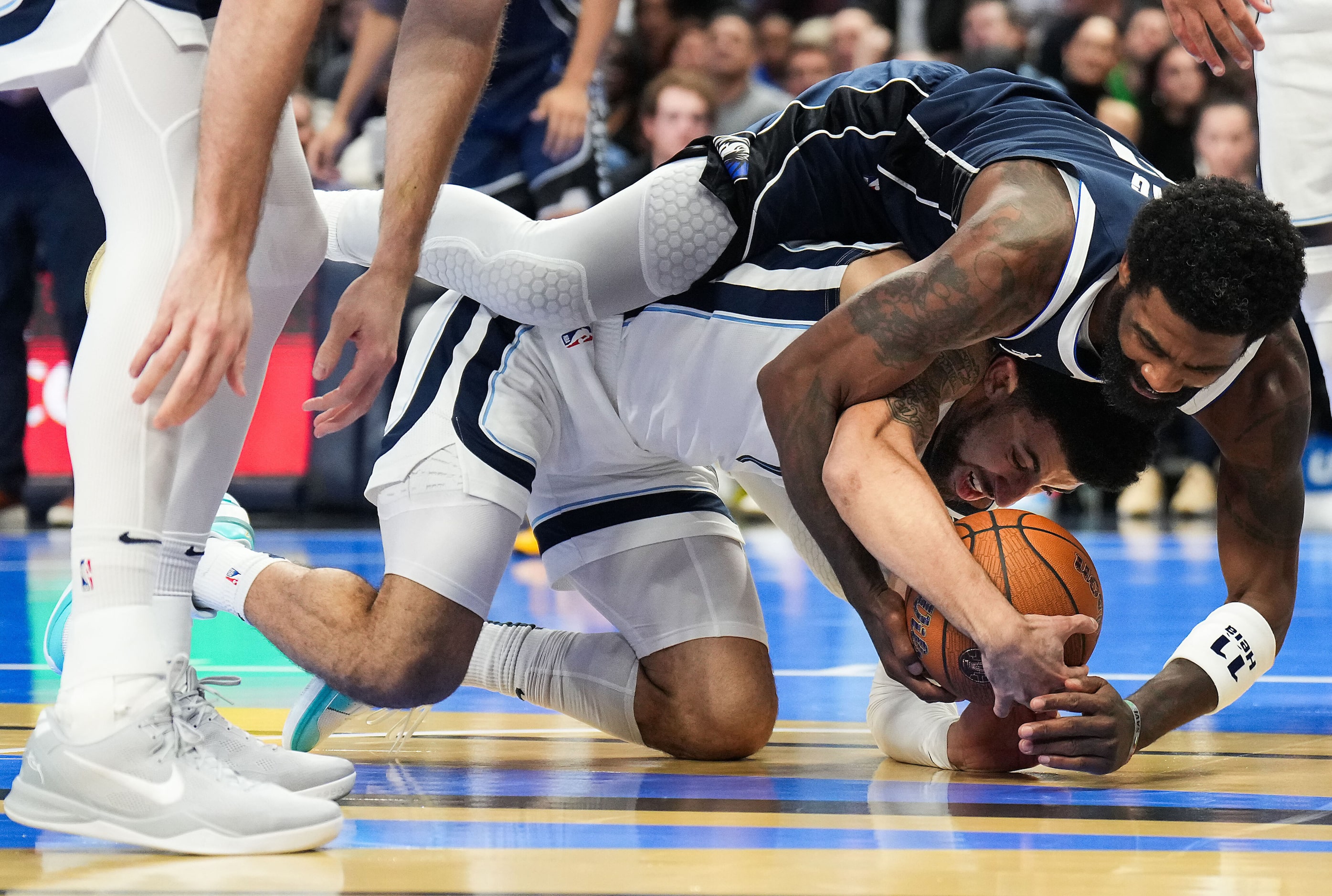 Dallas Mavericks guard Kyrie Irving (11) wrestles for a loose ball with Memphis Grizzlies...