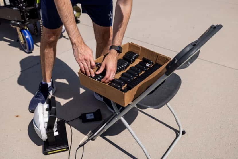 A member of the Cowboys training staff removes GPS devices and places them in a box for the...