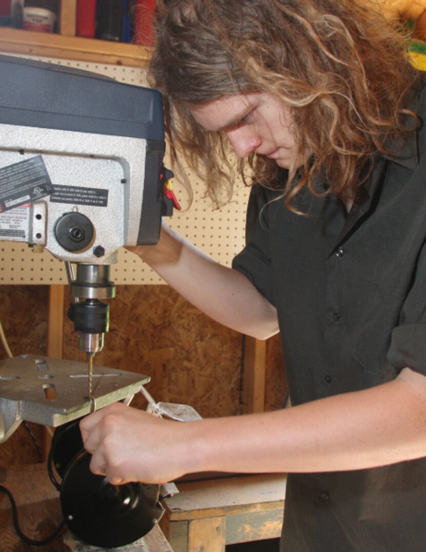 Gavin Pugh, 16, uses a drill press in a backyard shed to work on a ray gun part.
