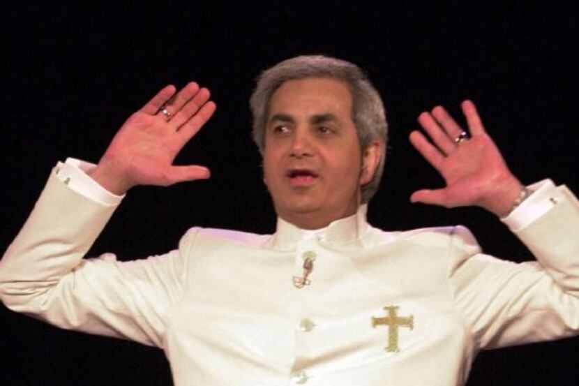Evangelist Benny Hinn,  raises his hands in prayer during a service at the Blaisdell Concert...