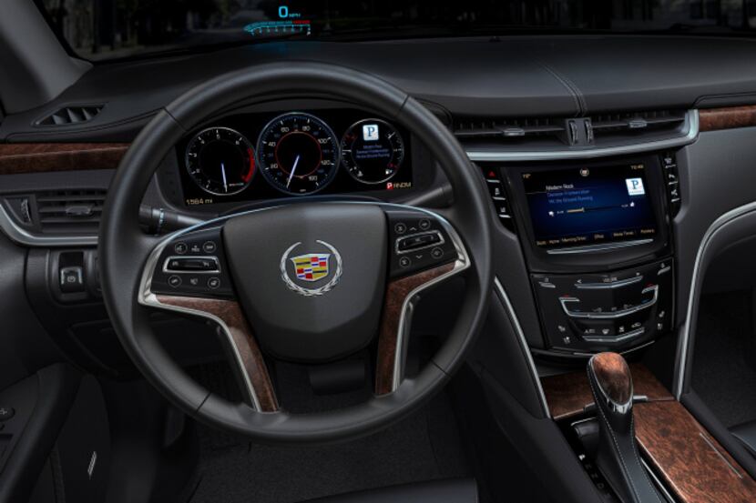 Interior of the 2013 Cadillac XTS showing the CUE system and widescreen LED dashboard.