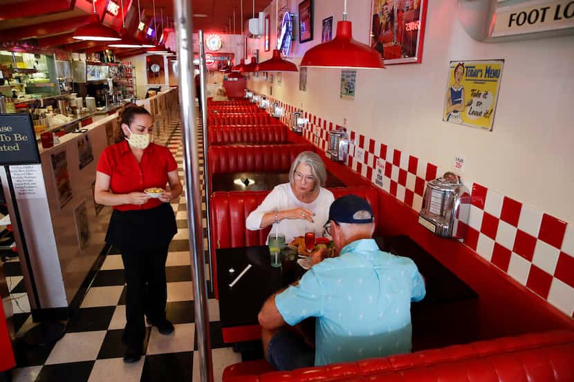 Lynn Tanner (al centro) y su esposo Ryan (derecha) almuerzan en el restaurante Busy Bee Cafe...