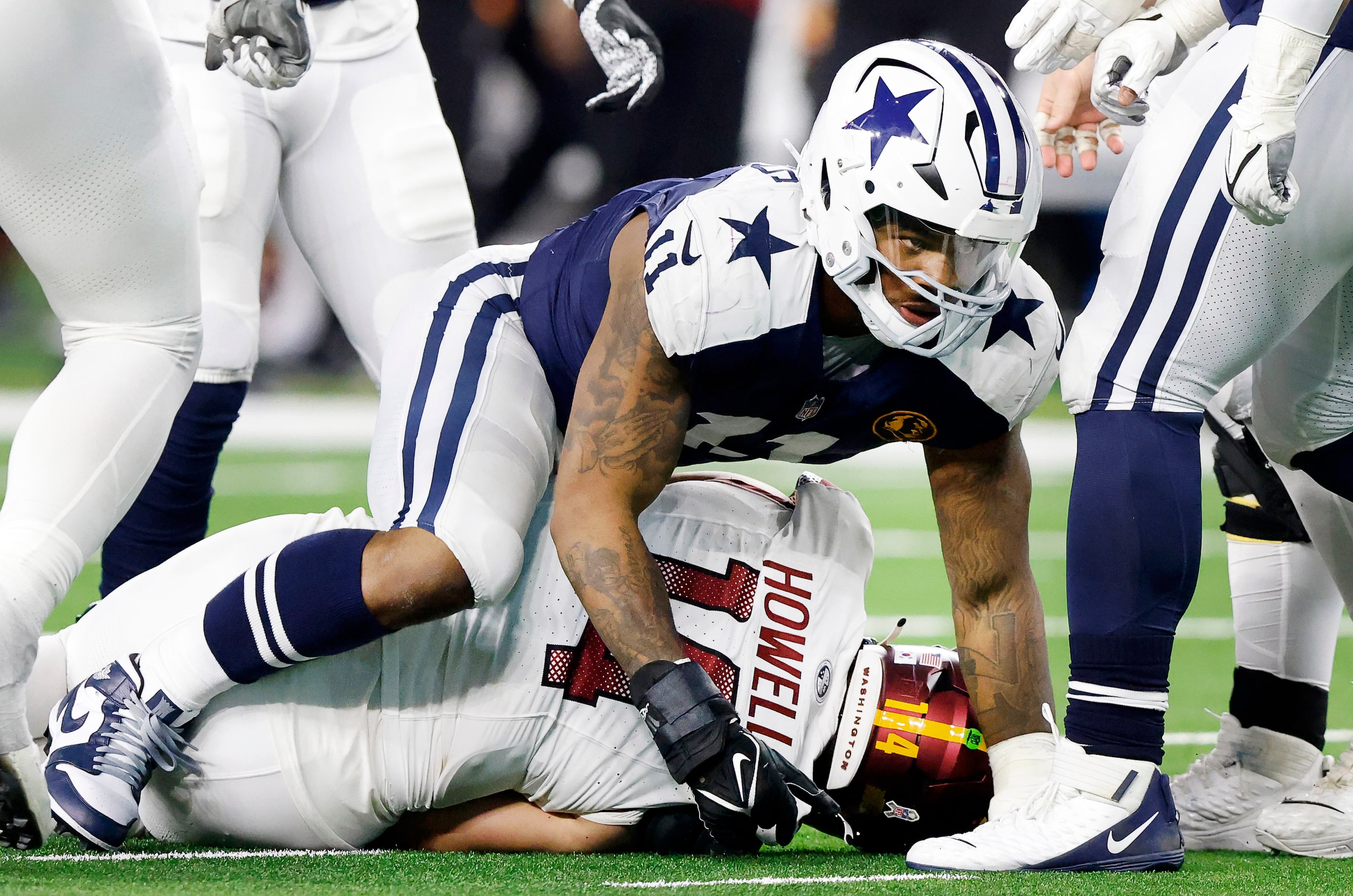 Dallas Cowboys linebacker Micah Parsons (11) crawls off of Washington Commanders quarterback...