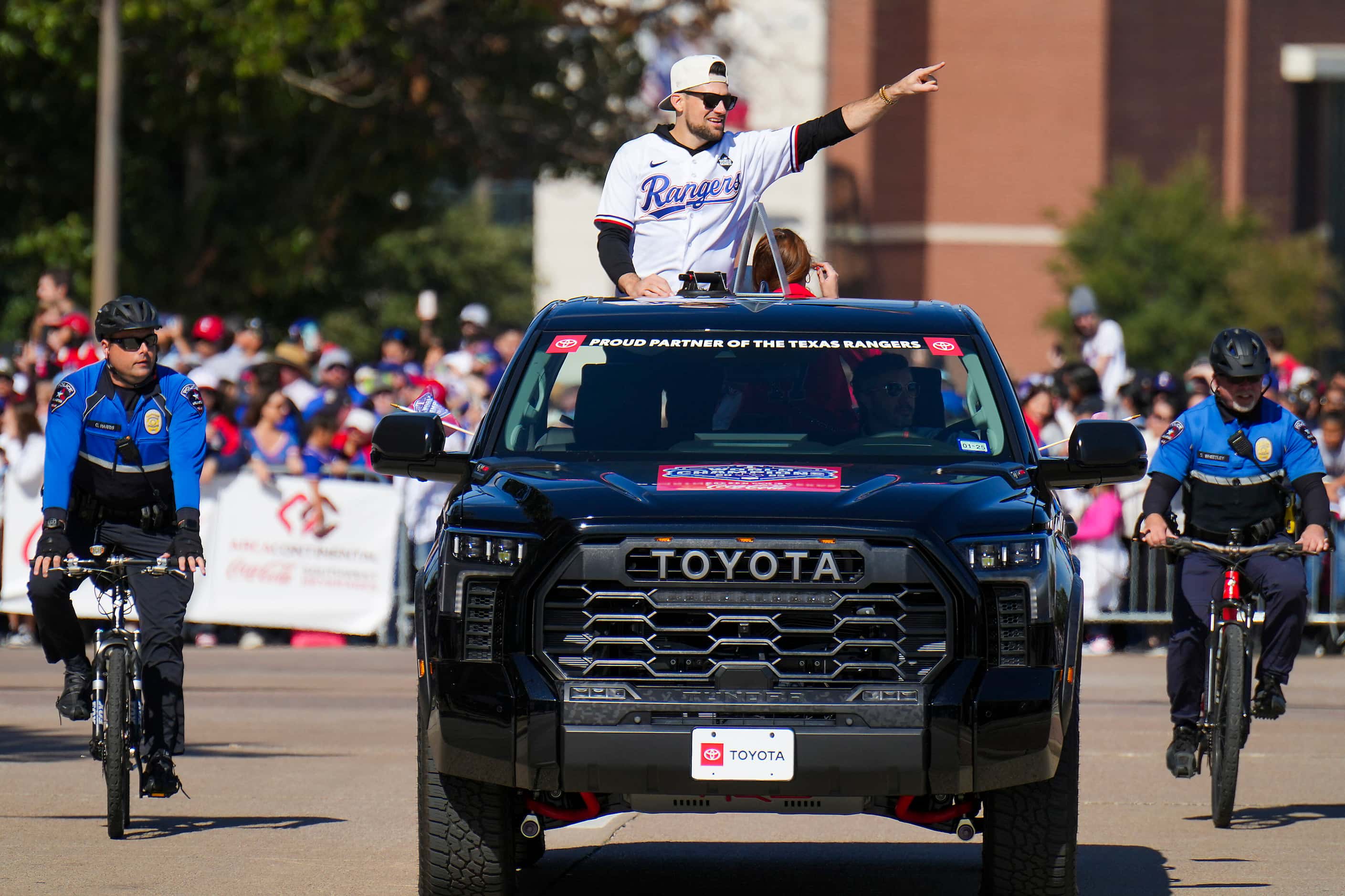 Texas Rangers starting pitcher Nathan Eovaldi waves to fans from the back of a truck during...