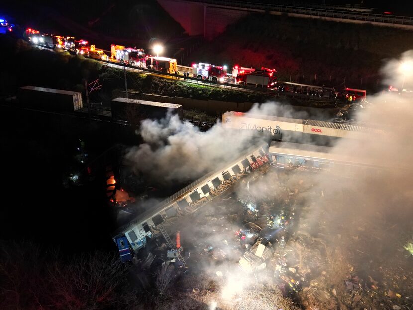 Smoke rises from the trains as fire and rescue personnel arrive at the scene. Greece’s...