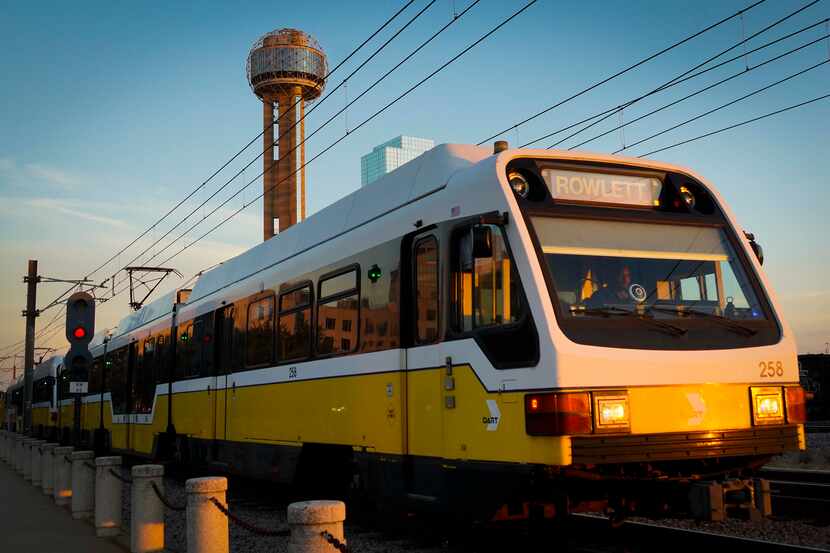 A DART rail Blue Line train heads away Union Station in front of Reunion Tower on Friday,...