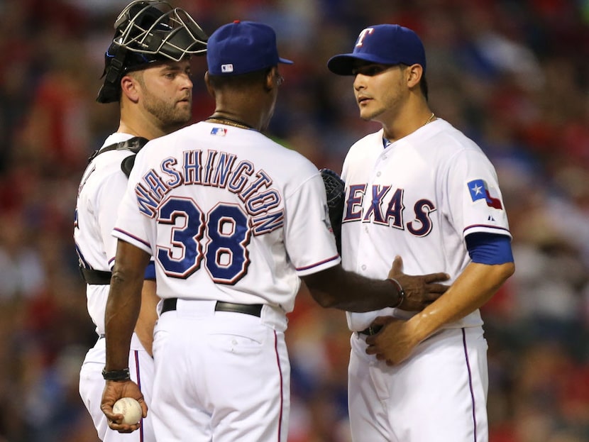 Texas manager Ron Washington talks to Rangers starter Martin Perez as he pulls him from the...