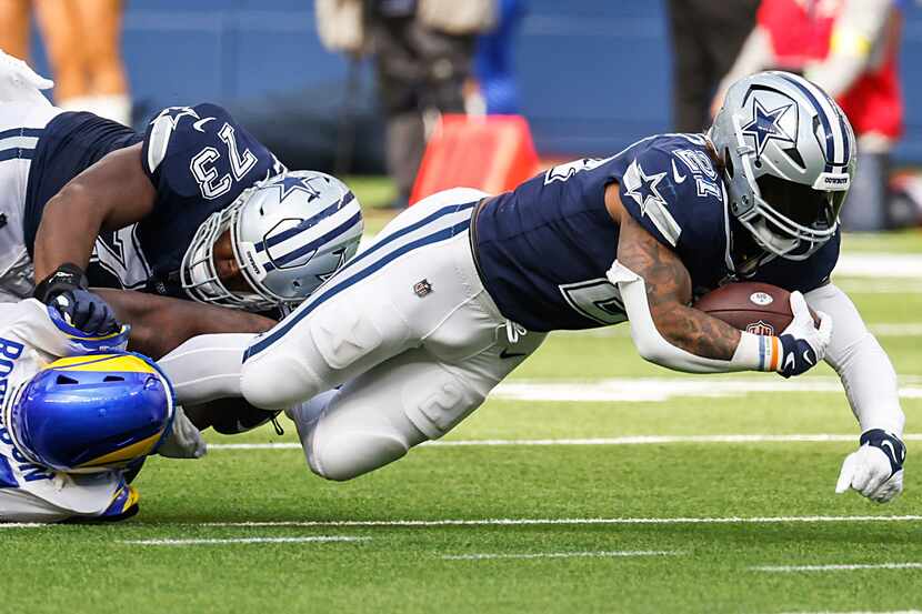 Dallas Cowboys running back Ezekiel Elliott (21) is brought down by Los Angeles Rams...
