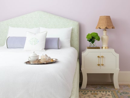 A custom Boulder bed from Scout Design bed pops against a lilac wall. The nightstand is the...