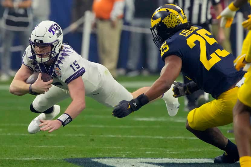 TCU quarterback Max Duggan (15) dives for yardage as Michigan linebacker Junior Colson (25)...