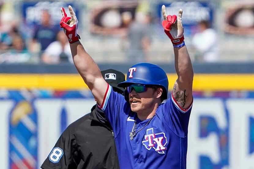Texas Rangers infielder Brock Holt celebrates at second base after hitting a leadoff double...