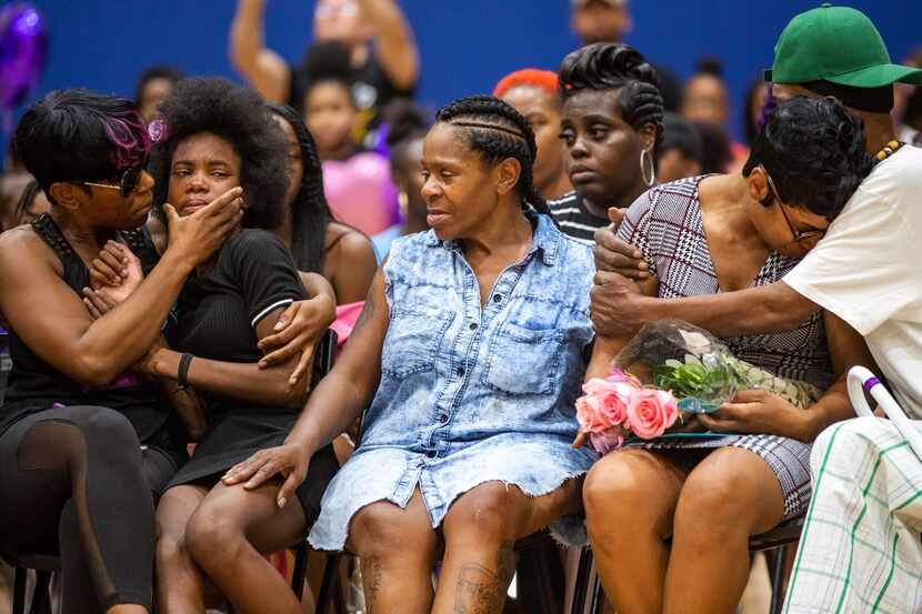 Sontravia Elder, second from right, is hugged while she and other family members gather to...
