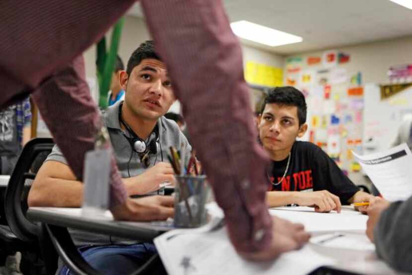 
Maria Chuchilla, 17, and Gabriel Guzman, 17, both from El Salvador, listen to classmates...