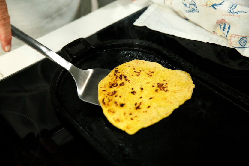 Dotty Griffith cooks flour tortillas on a comal.