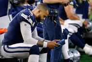 Dallas Cowboys quarterback Dak Prescott (4) looks at a tablet on the bench after he couldn't...