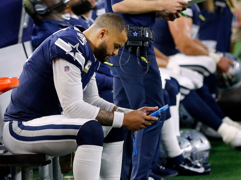 Dallas Cowboys quarterback Dak Prescott (4) looks at a tablet on the bench after he couldn't...