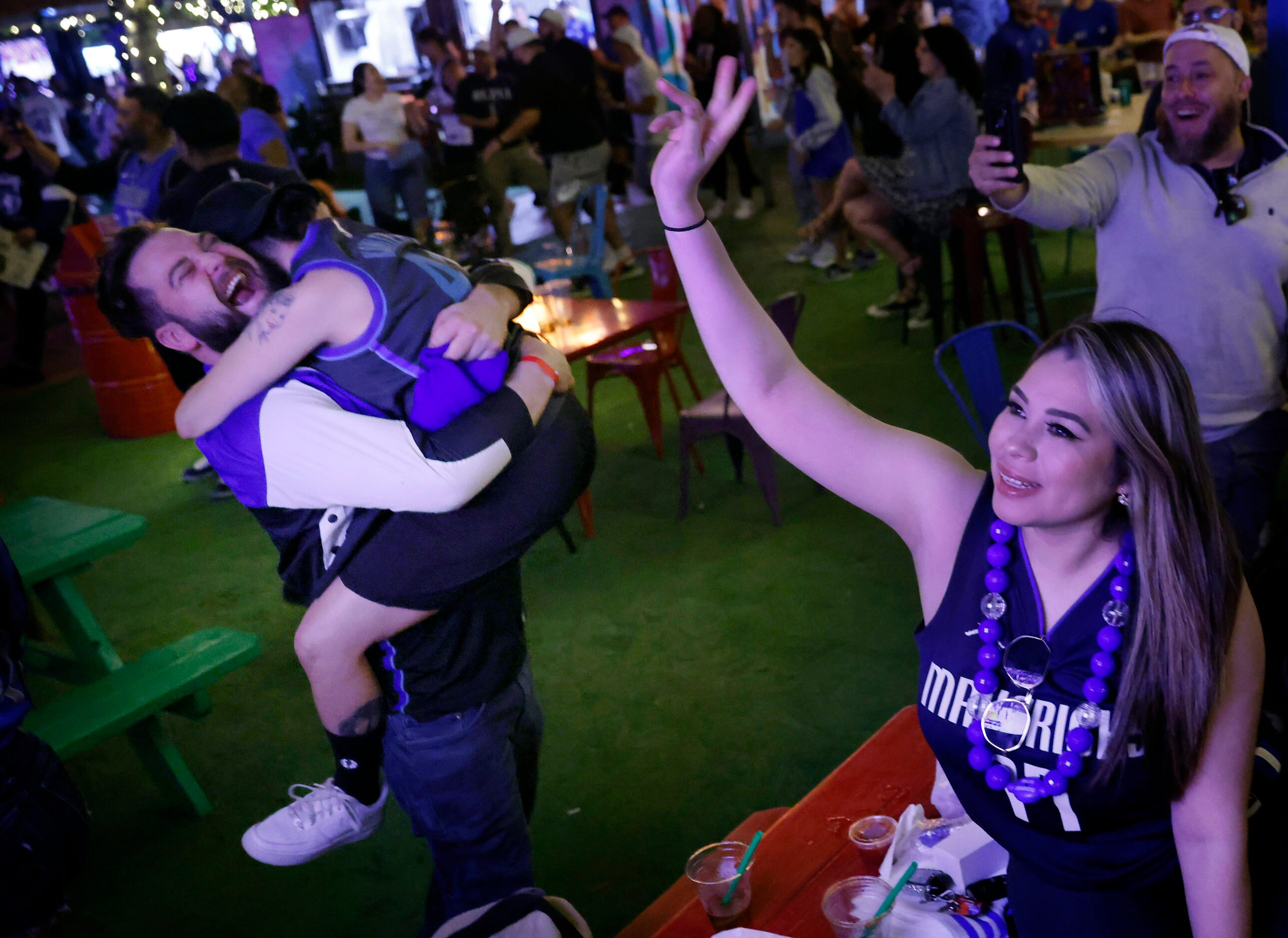 Dallas Mavericks fans Vanessa Castaneda jumps into Grant Burkett’s arms after the Mavs...