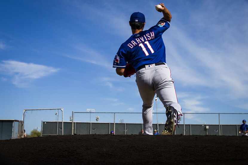 Texas Rangers pitcher Yu Darvish throws off a pitching mound in the bullpen during a spring...