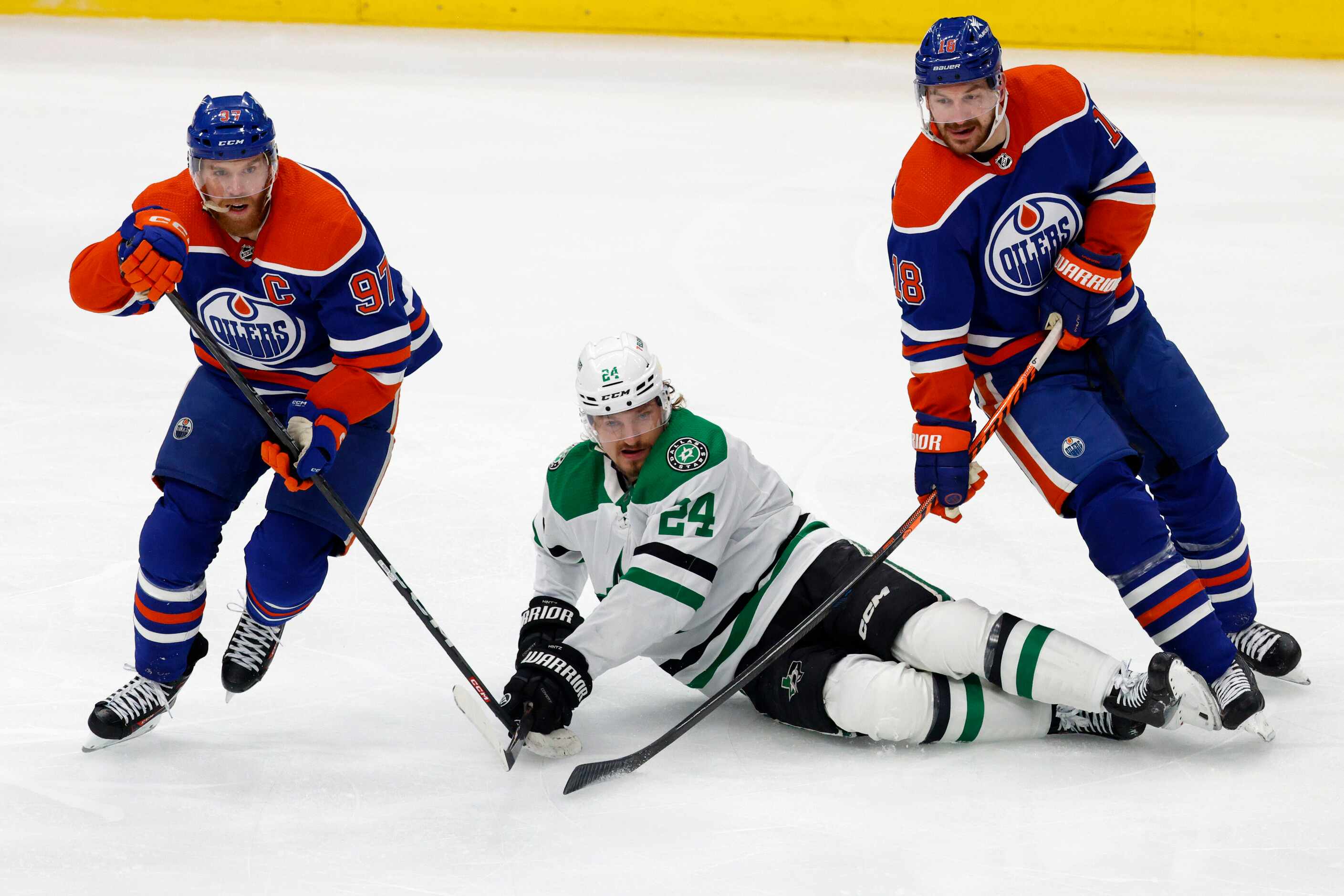 Dallas Stars center Roope Hintz (24) falls to the ice between Edmonton Oilers center Connor...