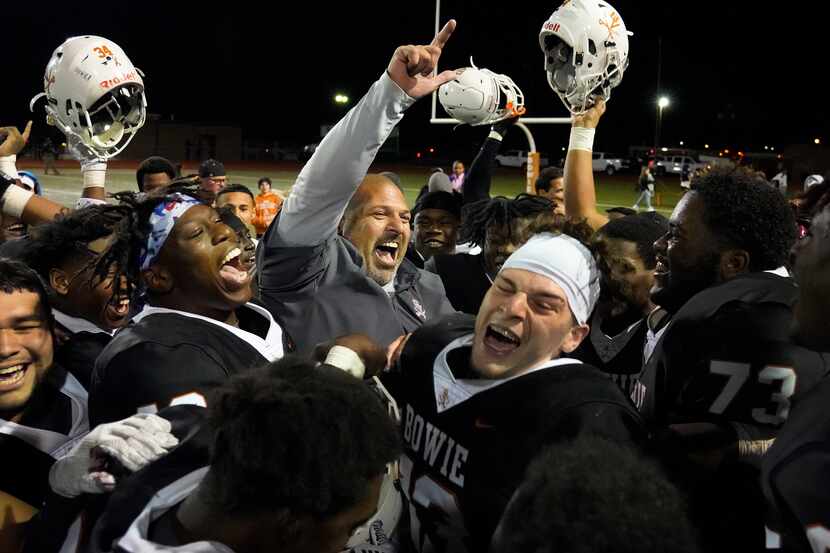 Arlington Bowie head coach Danny DeArman celebrates with his players after a victory over...