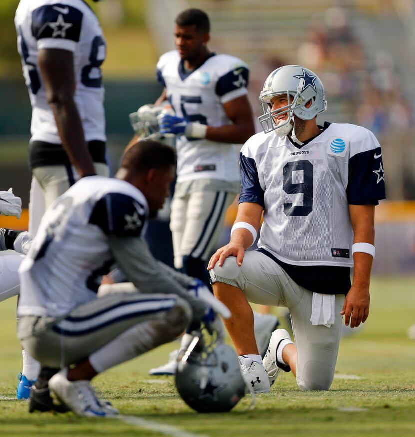 Dallas Cowboys quarterback Tony Romo (9) visits with wide receiver Dez Bryant (88) during a...