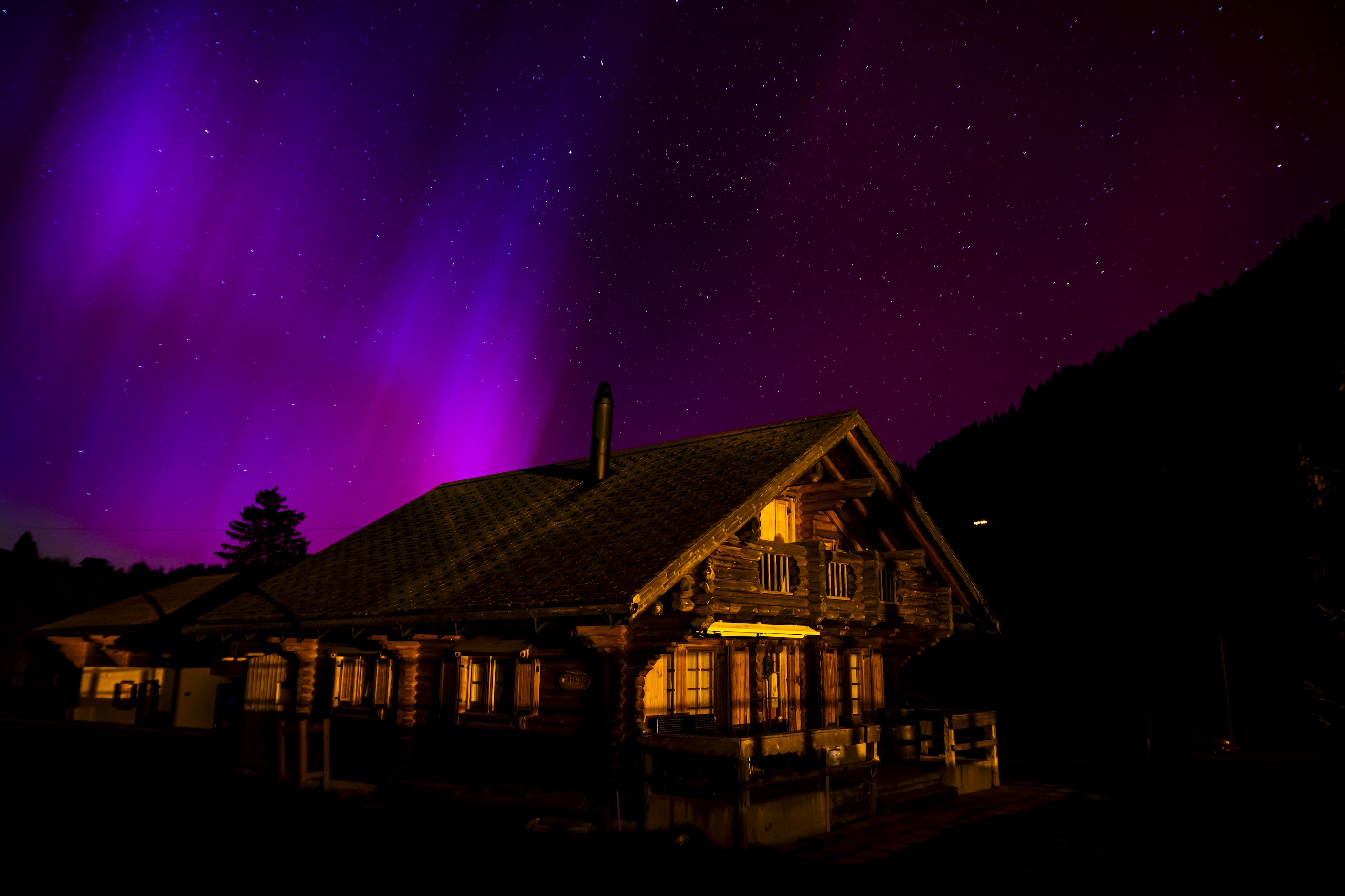 The Northern Lights, or Aurora Borealis, illuminate the night sky over the mountains in Le...