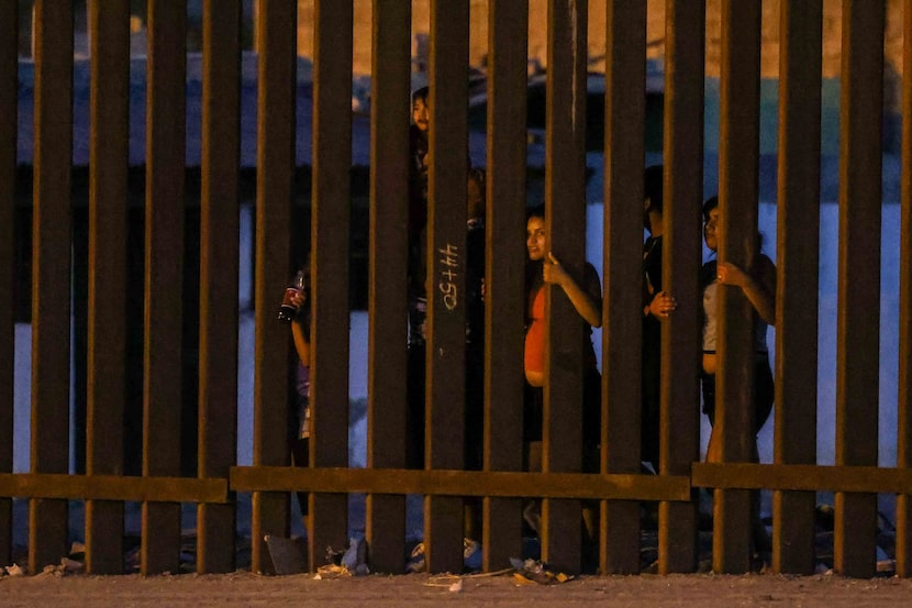 People on the Mexican side of the border watched Border Patrol agents in Sunland Park, N.M.,...