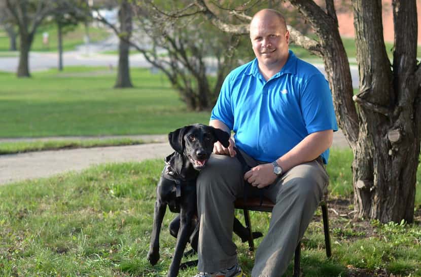In this March 2012 photo provided by Paws & Effect, Wade Allen Baker sits with Honor at the...