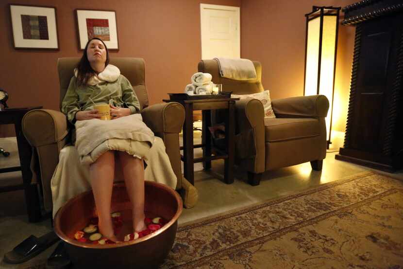 Christy Bradford has her feet submerged in an assortment of cucumber, rose petals and Epsom...