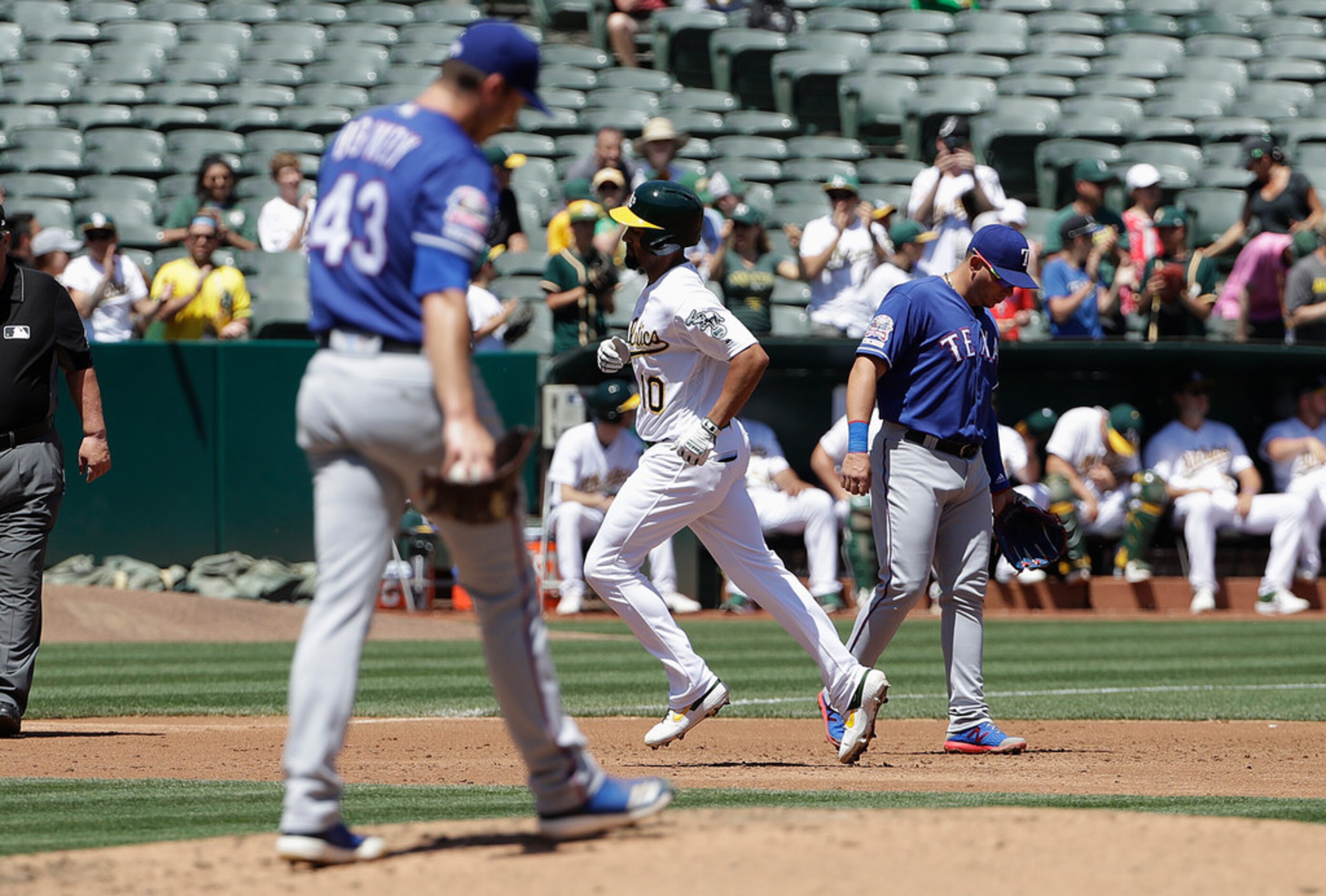 Oakland Athletics' Marcus Semien, center, rounds the bases after hitting a three-run home...