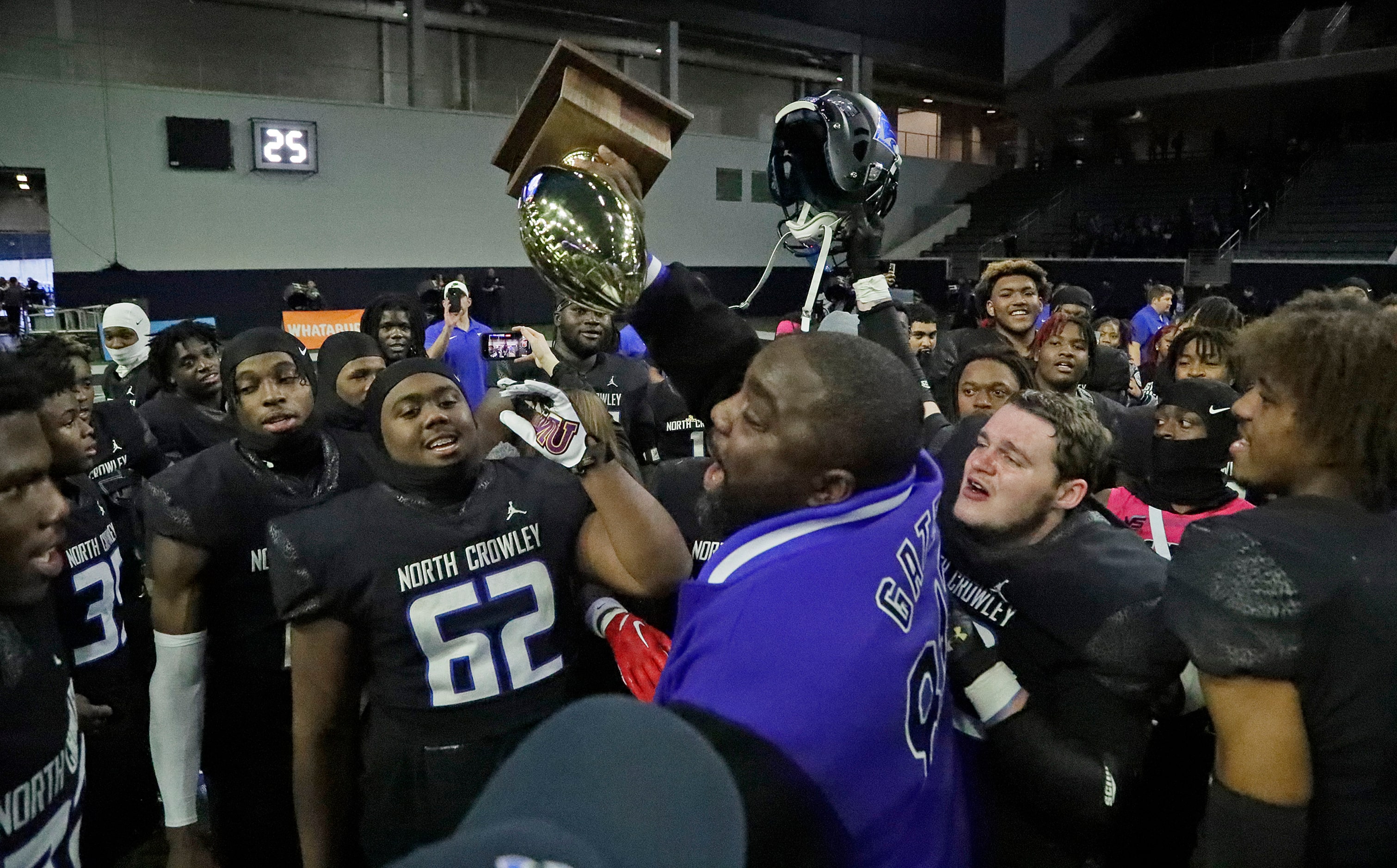 North Crowley High School head coach Ray Gates holds up the trophy after North Crowley High...