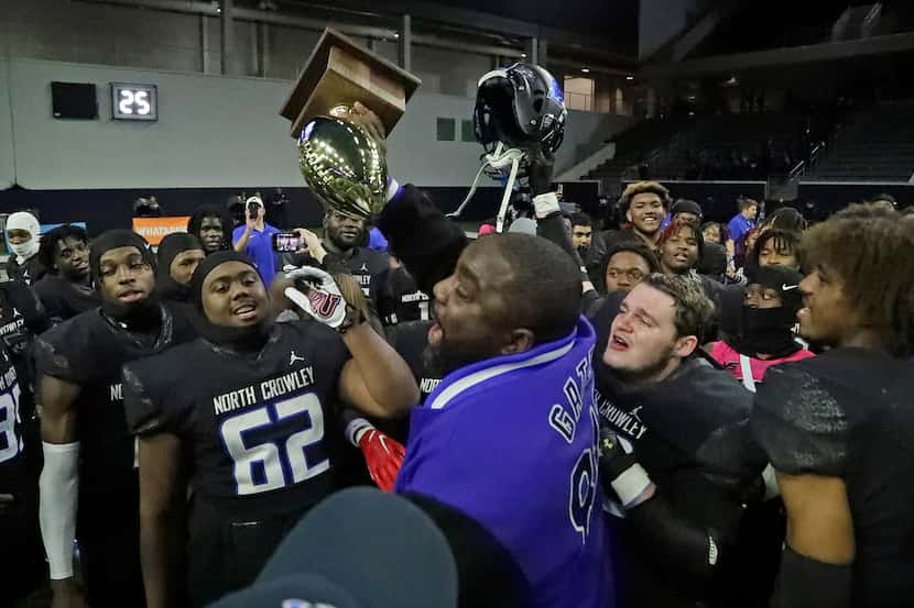 North Crowley High School head coach Ray Gates holds up the trophy after North Crowley High...