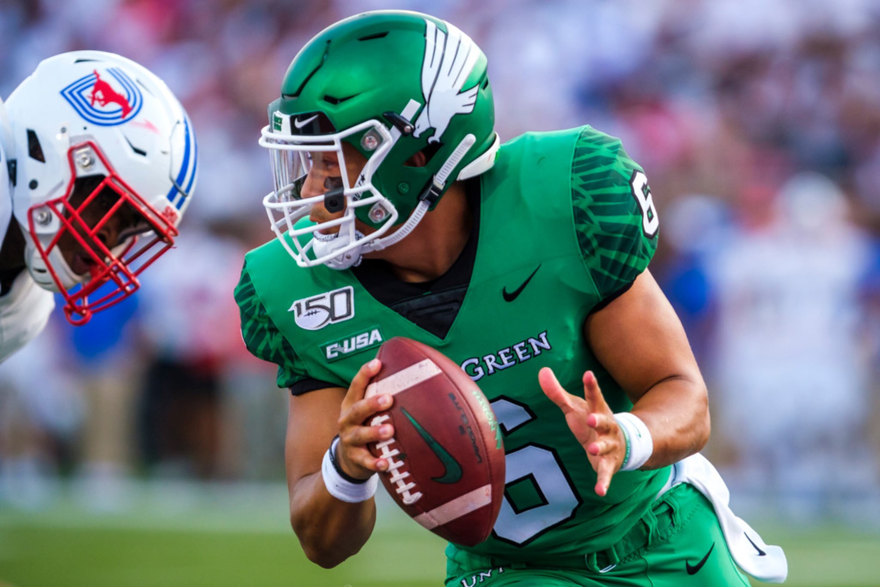 UNT quarterback Mason Fine (6) scrambles away from the SMU pass rush during the first half...