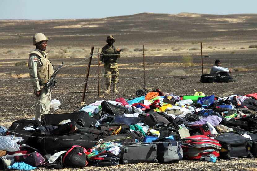 Egyptian Army soldiers stand near luggage and personal effects of passengers a day after a...